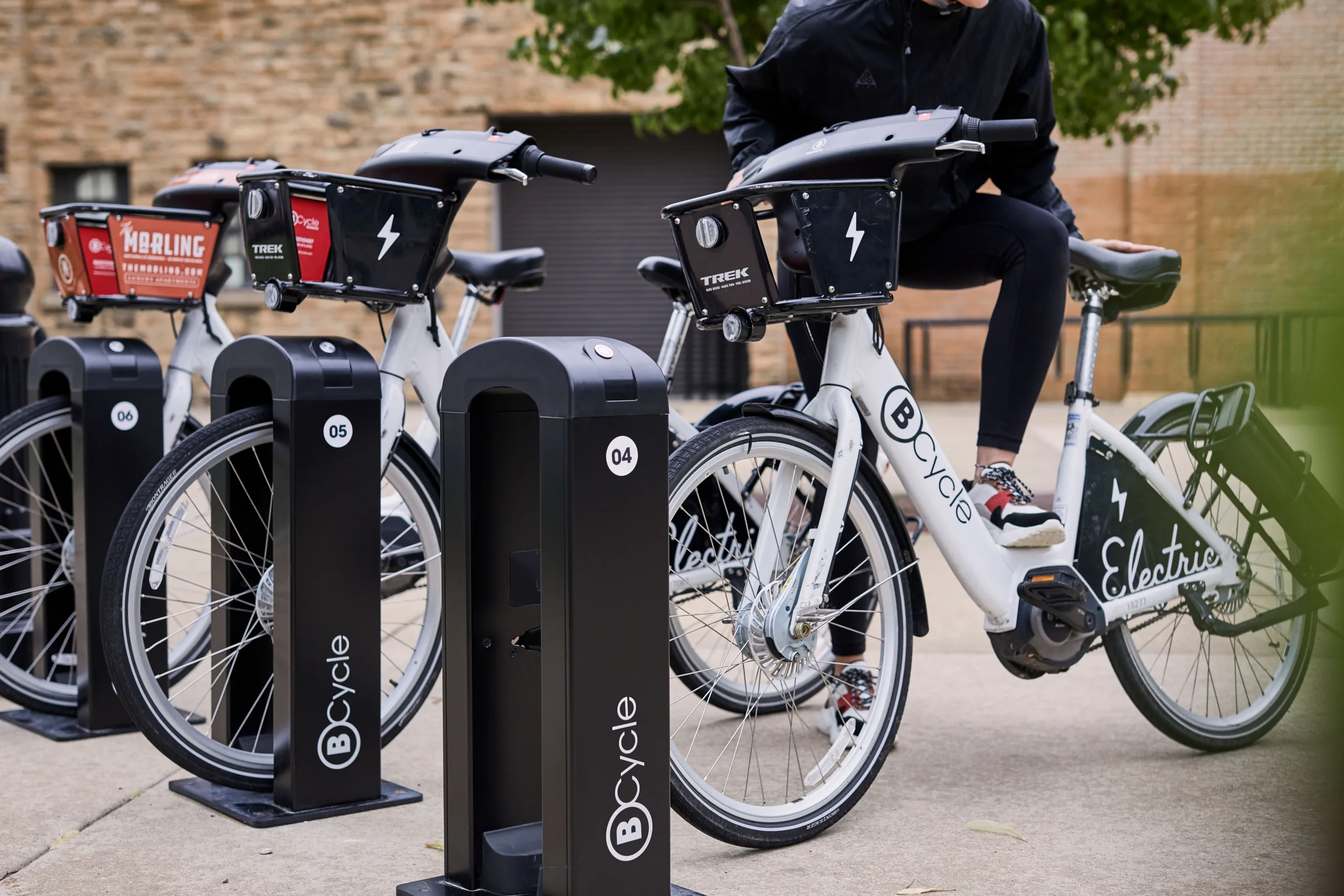 legs mounting a docked bike share bicycle
