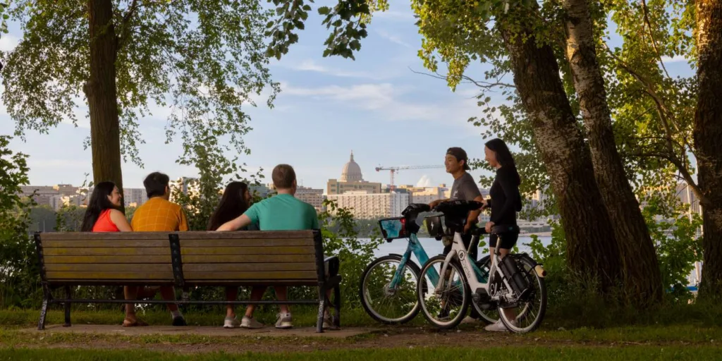 people enjoying the view of the lake, two people arrive on bike share bicycles