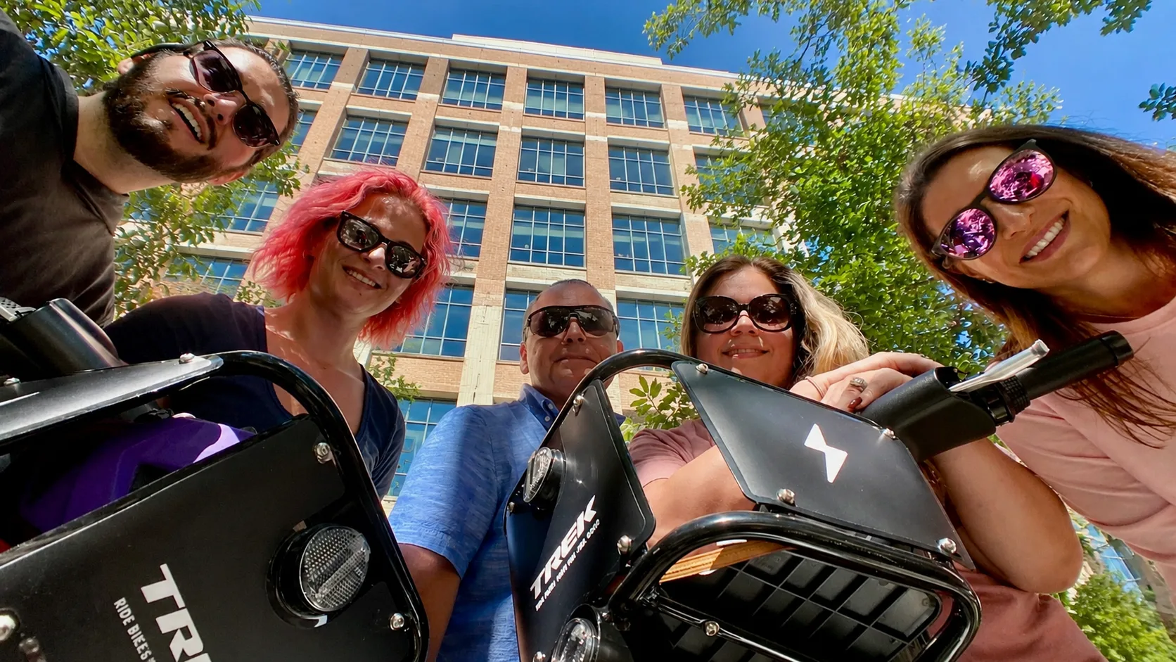 group of people looking over the handle bars of their bike share bicycles